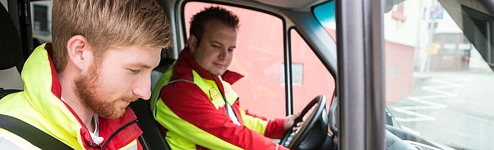 Zwei Personen in einem Rettungswagen.