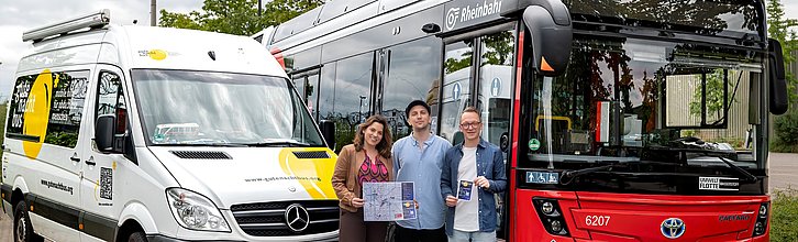 Drei Personen stehen vor einem Linienbus der Rheinbahn und dem Kleinbus "gutenachtsbus".