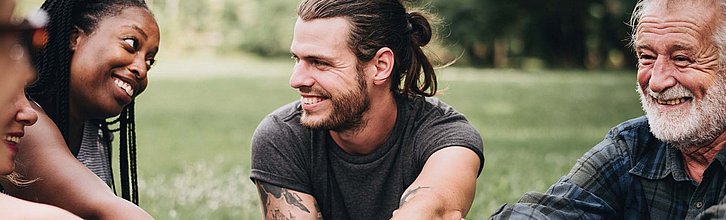 Verschiedene Menschen lächeln sich an