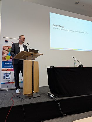 Christian Woltering steht auf einer Bühne hinter einem Rednerpult.