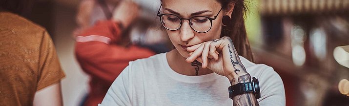 Frau schaut auf Papier und schreibt etwas auf