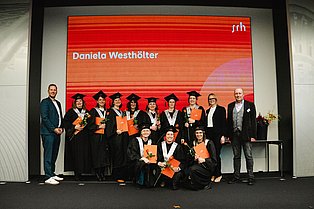 Gruppenbild der Absolvent*innen mit zwei Männern, einer davon ist Christian Woltering