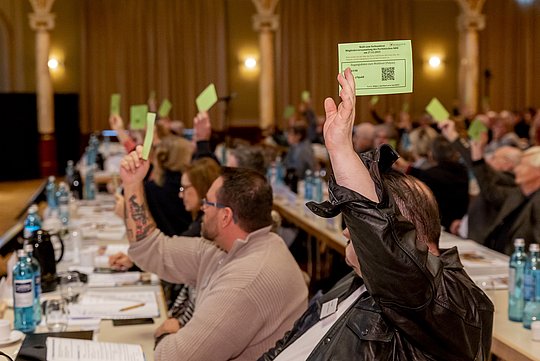 Menschen halten Stimmkarten nach oben