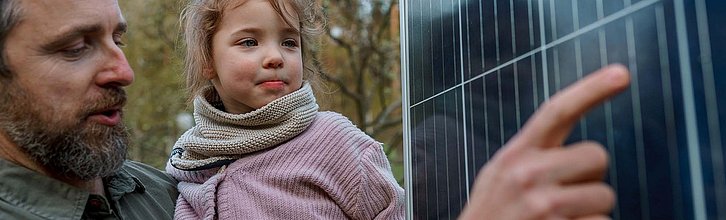 Mann zeigt Kind eine Photovoltaikanlage