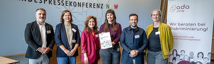 Gruppenbild der ADA-Jahresbericht-Verantwortlichen. Person in der Mitte hält Jahresbericht 2025 in die Kamera.