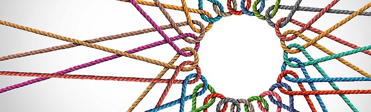 Bunte Fäden, die zu einem Netz zusammengesponnen sind.
